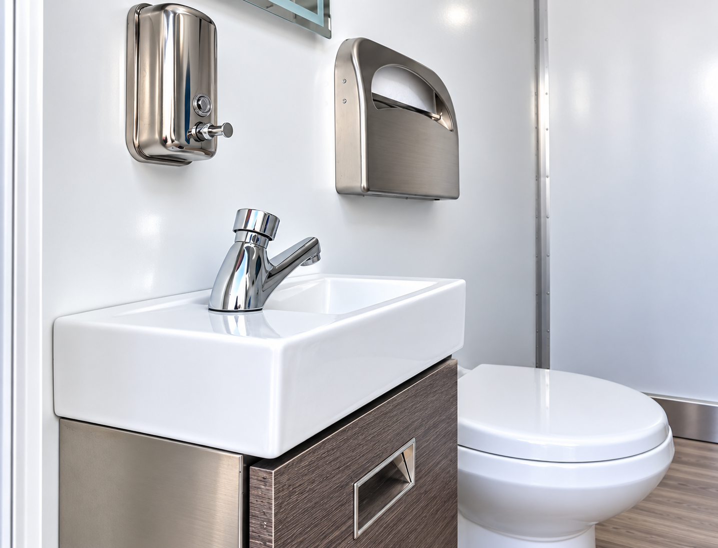 Sink, dispensers and toilet inside a mobile restroom