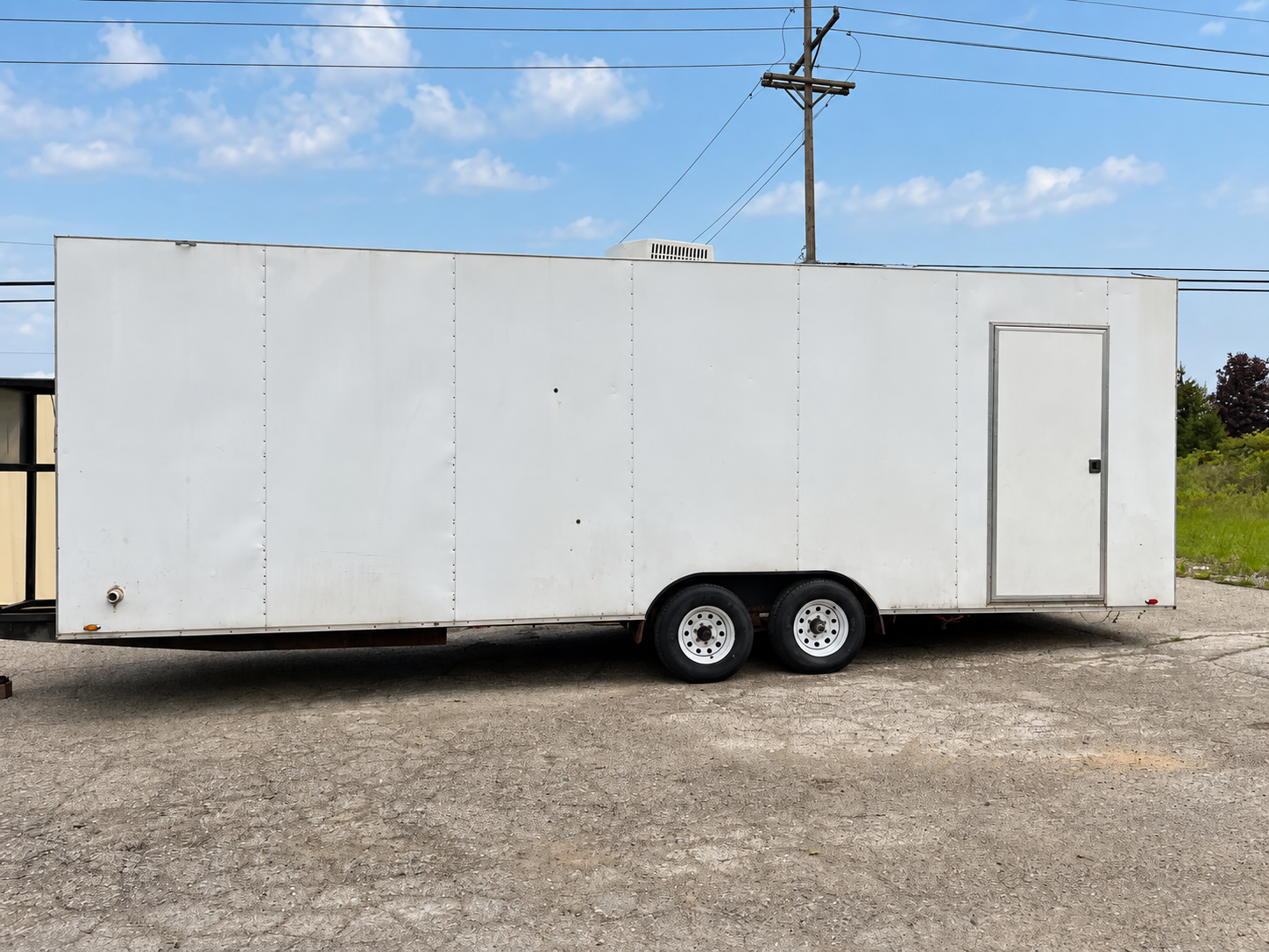 Side of a long white enclosed trailer